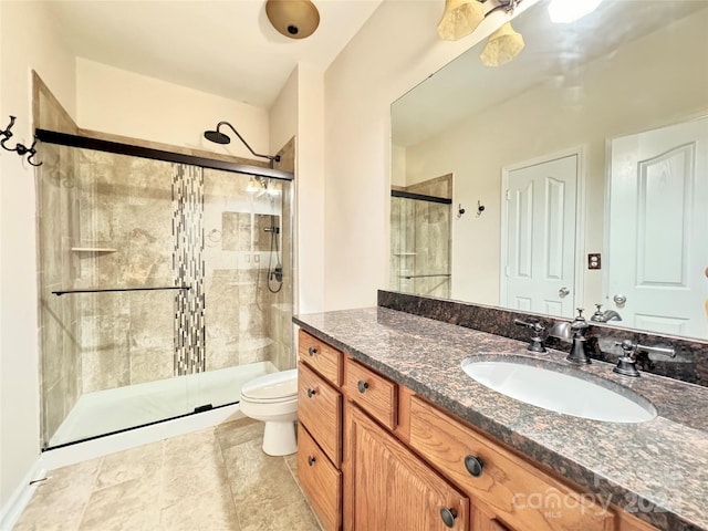 full bathroom featuring a shower stall, toilet, and vanity