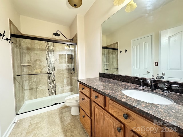 bathroom featuring a shower stall, toilet, and vanity