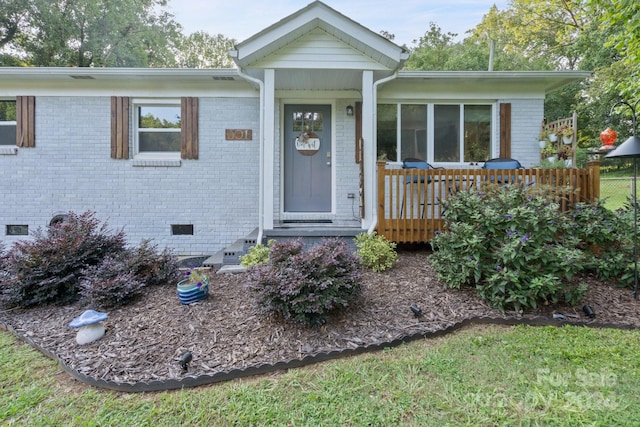 property entrance featuring crawl space and brick siding