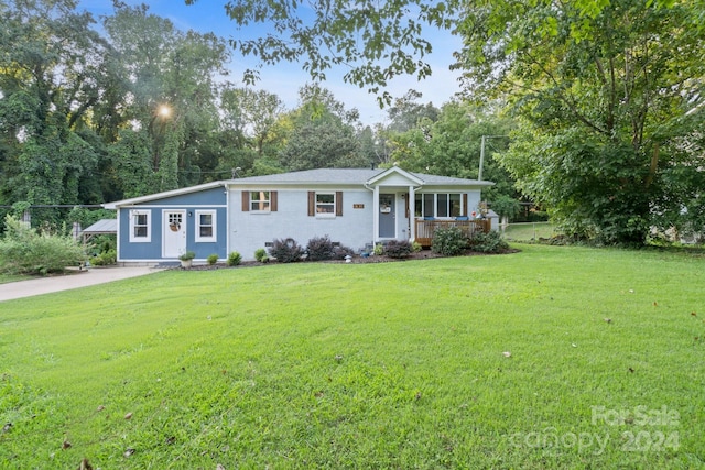 ranch-style house with covered porch and a front lawn