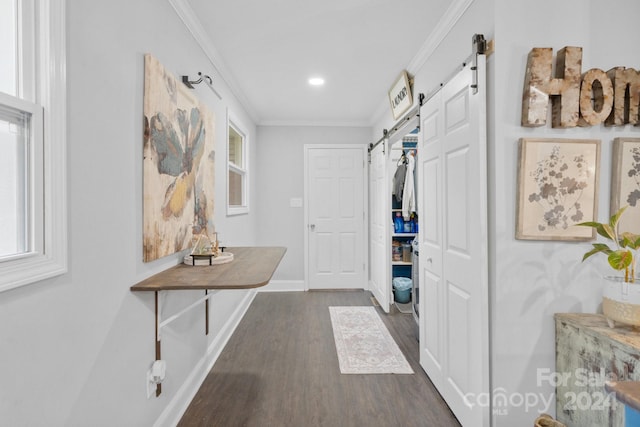 interior space featuring ornamental molding, a barn door, and dark hardwood / wood-style floors