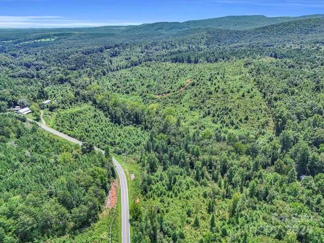 aerial view featuring a forest view and a mountain view