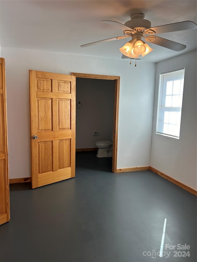 interior space with concrete floors, baseboards, and ceiling fan