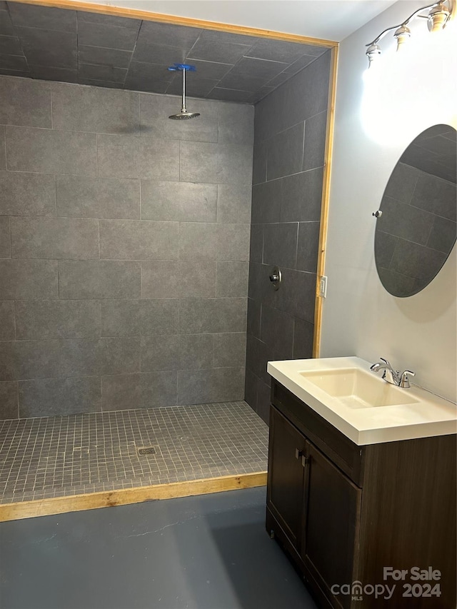 bathroom featuring a tile shower and vanity