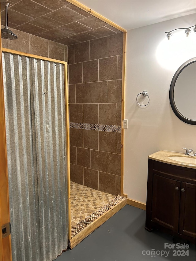 full bathroom featuring baseboards, concrete floors, a shower stall, and vanity