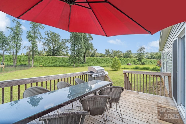 wooden deck with a grill, outdoor dining area, and a lawn