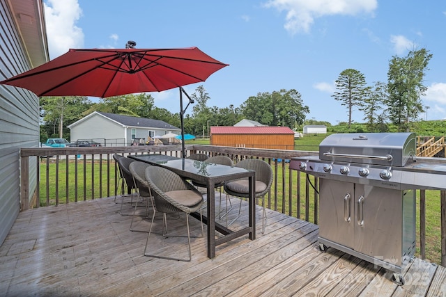 deck featuring a grill, outdoor dining area, and a yard