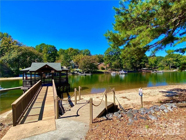 view of dock with a gazebo and a water view