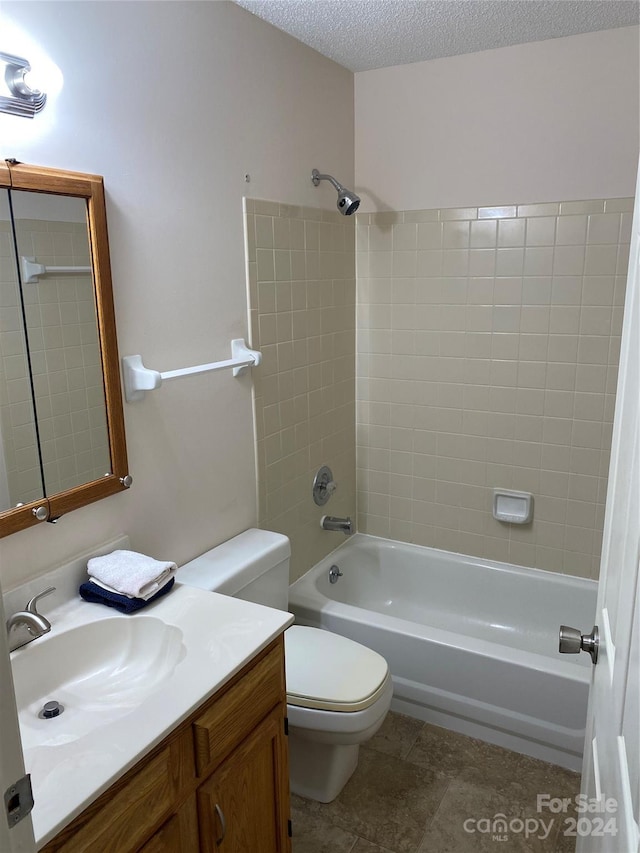 full bathroom with vanity, tiled shower / bath, tile patterned flooring, toilet, and a textured ceiling