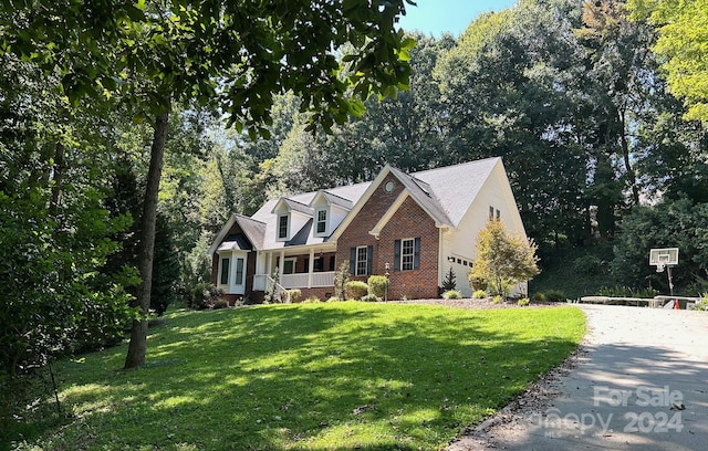 cape cod home with covered porch and a front lawn