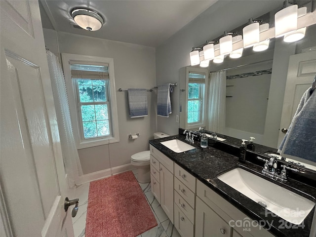 bathroom with vanity, toilet, curtained shower, and tile patterned floors