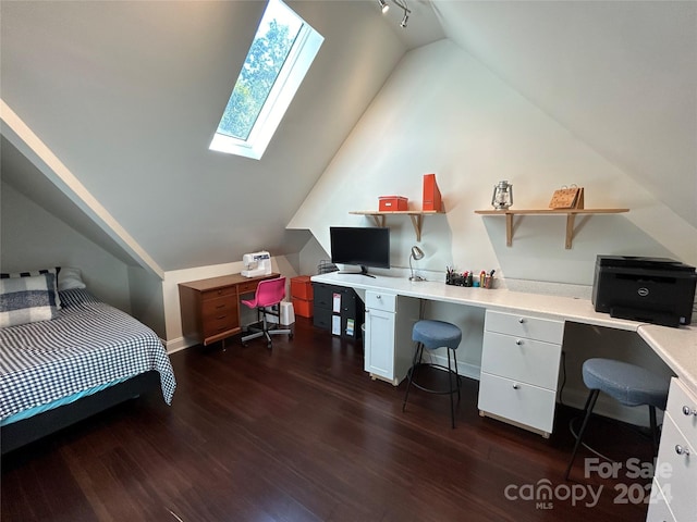 bedroom featuring vaulted ceiling with skylight, dark hardwood / wood-style flooring, and built in desk