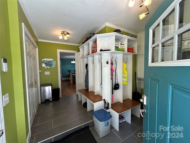 mudroom featuring crown molding and dark tile patterned flooring