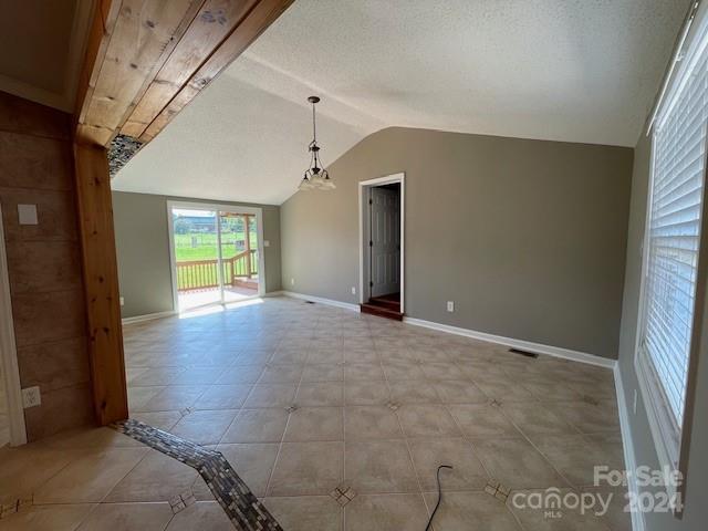 spare room featuring light tile patterned floors and a textured ceiling