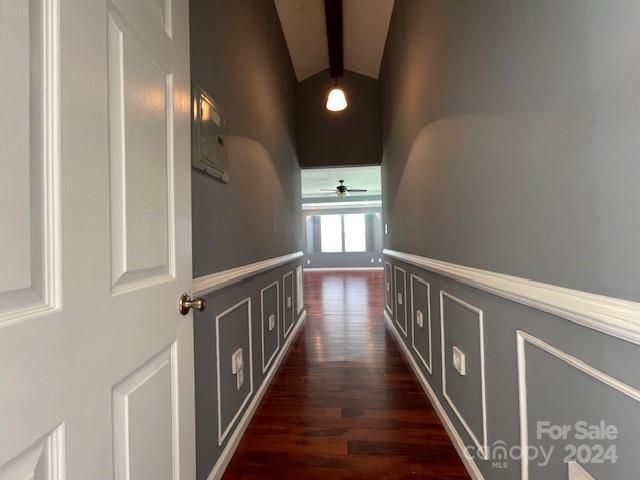 hallway with lofted ceiling with beams and dark hardwood / wood-style floors