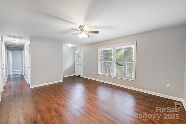 empty room with ceiling fan and dark hardwood / wood-style flooring