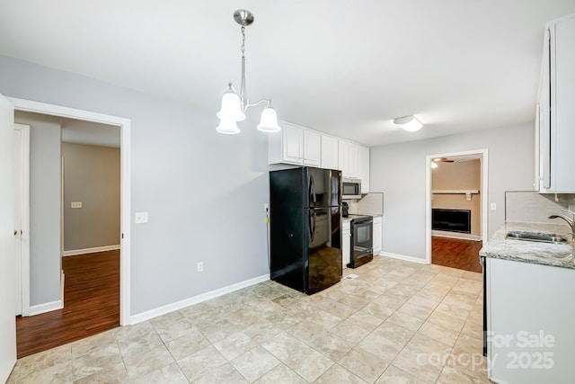 kitchen featuring white cabinetry, black appliances, sink, decorative backsplash, and pendant lighting