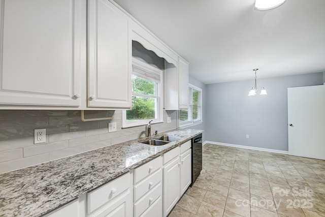 kitchen with light stone counters, white cabinets, backsplash, sink, and black dishwasher