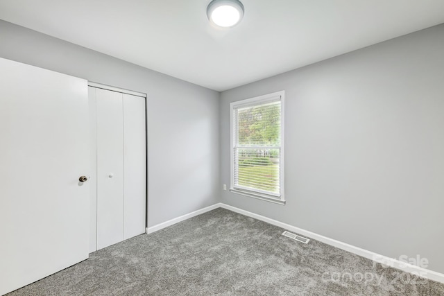 unfurnished bedroom with a closet and carpet floors