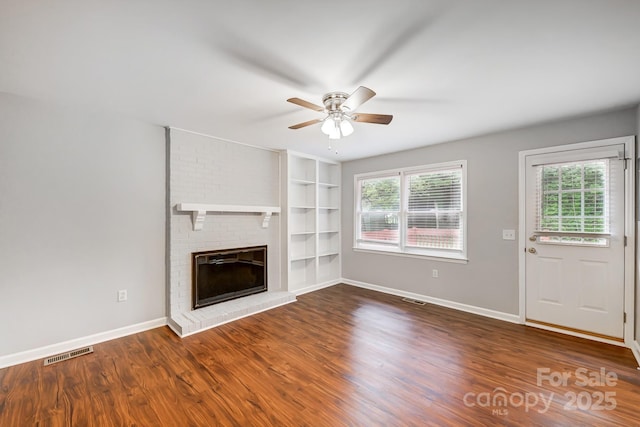 unfurnished living room with a fireplace, hardwood / wood-style flooring, built in shelves, and ceiling fan