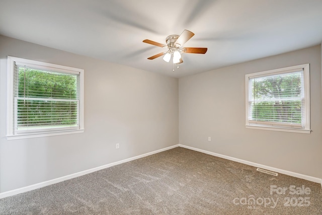 unfurnished room with ceiling fan and carpet