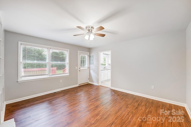 empty room featuring ceiling fan and dark wood-type flooring