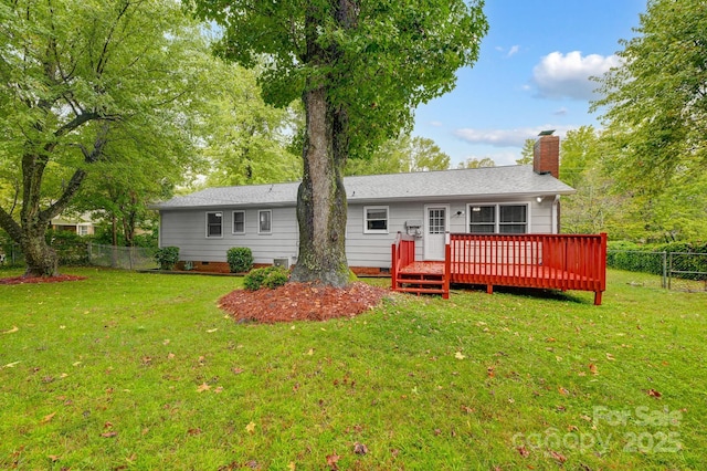 rear view of property with a yard and a wooden deck