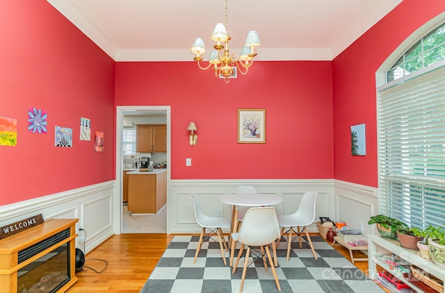 interior space featuring light hardwood / wood-style floors, an inviting chandelier, and ornamental molding