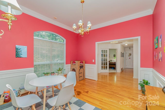 dining room featuring a chandelier, ornamental molding, and hardwood / wood-style flooring