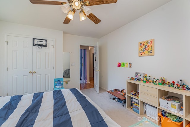 bedroom with a closet, ceiling fan, and light carpet