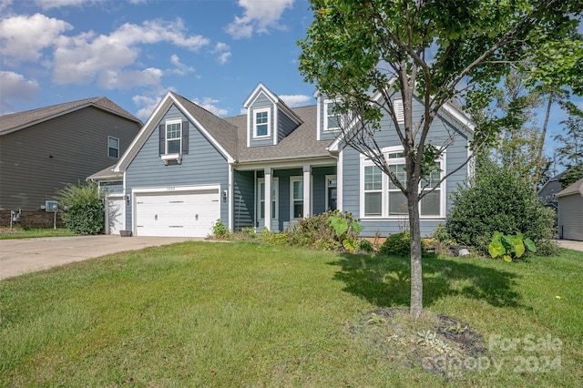 view of front of property featuring a garage, a porch, and a front lawn