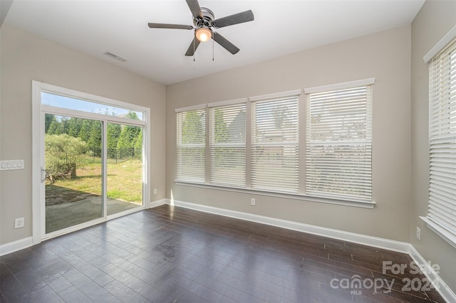 empty room with dark hardwood / wood-style floors and ceiling fan