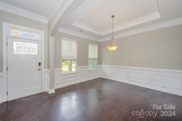 entrance foyer featuring a raised ceiling, crown molding, and dark hardwood / wood-style flooring