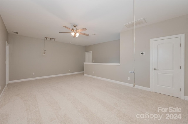 spare room featuring ceiling fan and light colored carpet