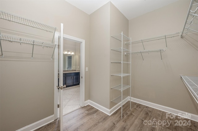 spacious closet with hardwood / wood-style floors and sink