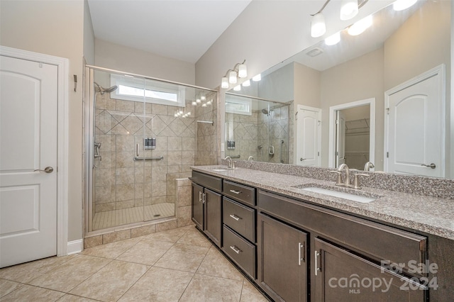 bathroom with tile patterned floors, a shower with shower door, and vanity