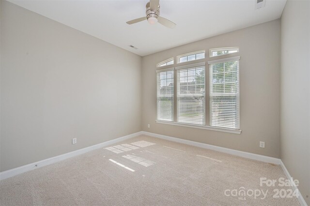 spare room with ceiling fan and light colored carpet