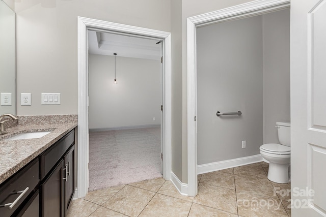 bathroom with vanity, tile patterned floors, baseboards, and toilet