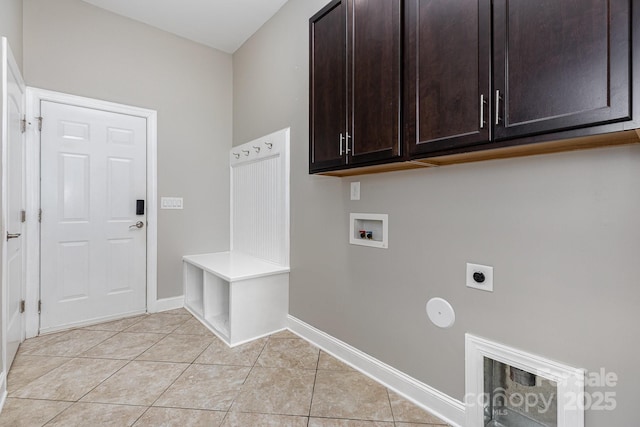 clothes washing area with baseboards, hookup for a washing machine, electric dryer hookup, cabinet space, and light tile patterned floors