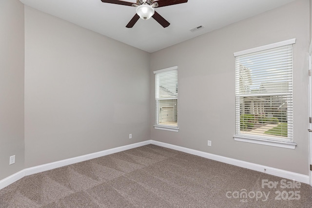 unfurnished room with ceiling fan, baseboards, and dark colored carpet