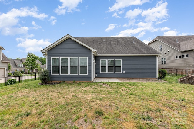 rear view of property featuring a lawn, a fenced backyard, and a patio