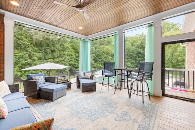 sunroom / solarium with ceiling fan and wooden ceiling