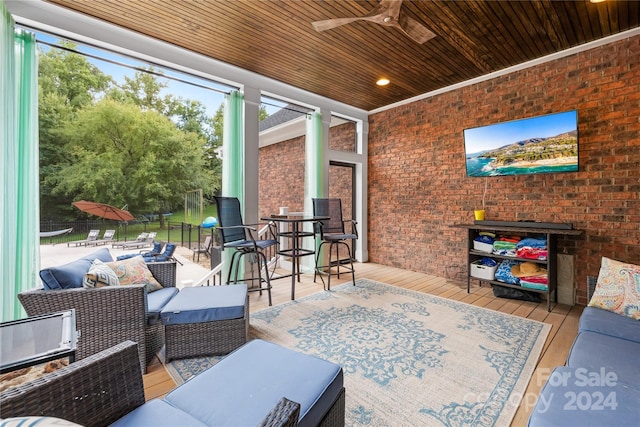 sunroom featuring ceiling fan and wood ceiling