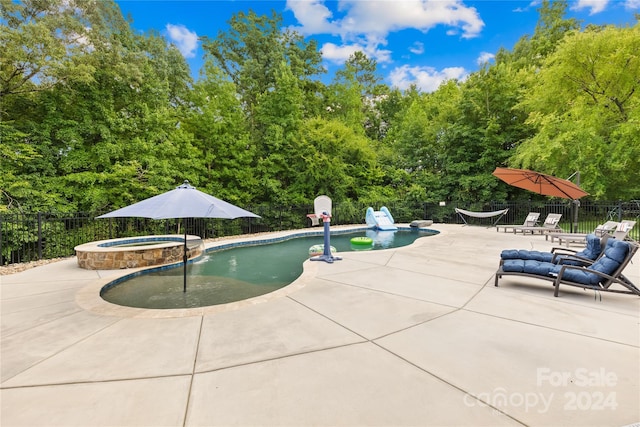 view of swimming pool with an in ground hot tub and a patio