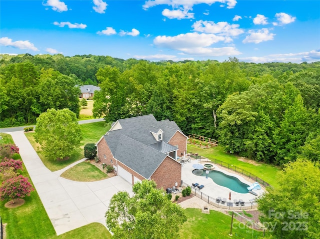 birds eye view of property featuring a wooded view