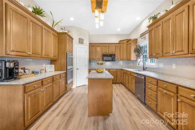 kitchen featuring stainless steel appliances, a center island, brown cabinetry, and a sink