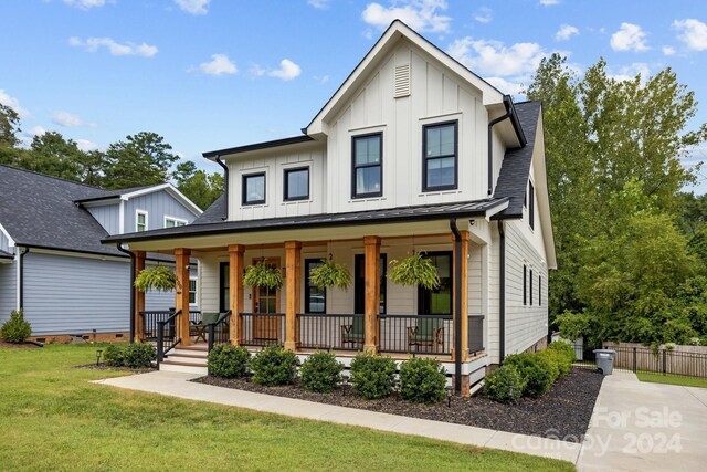 modern farmhouse featuring a porch and a front yard