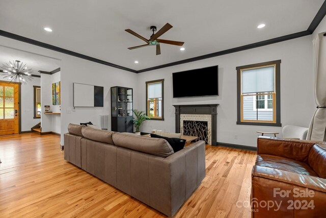 living room with a healthy amount of sunlight, light wood finished floors, a fireplace, and baseboards