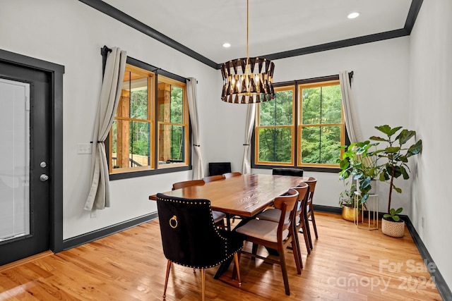 dining area with ornamental molding, a chandelier, baseboards, and light wood finished floors