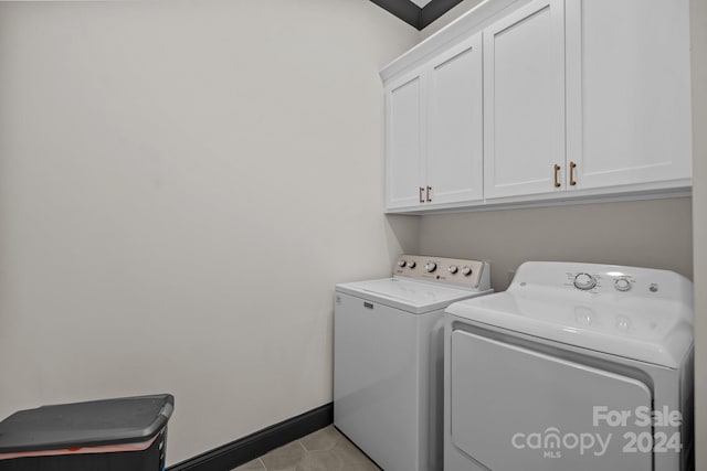 laundry room with cabinet space, light tile patterned floors, baseboards, and independent washer and dryer